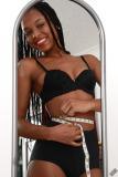 Caleann measuring herself in vintage black sixties-style bra and girdle