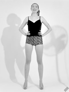 2026-08-01 Estella Rose models her own black sleeveless top and tight animal-print retro girdle worn as hotpants.
