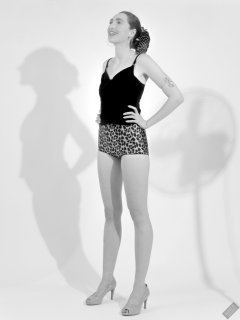 2026-08-01 Estella Rose models her own black sleeveless top and tight animal-print retro girdle worn as hotpants.