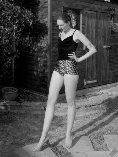 2026-08-01 Estella Rose models her own black sleeveless top and tight animal-print retro girdle worn as hotpants.