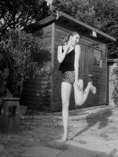 2026-08-01 Estella Rose models her own black sleeveless top and tight animal-print retro girdle worn as hotpants.