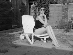 2026-08-01 Estella Rose models her own black sleeveless top and tight animal-print retro girdle worn as hotpants.