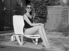2026-08-01 Estella Rose models her own black sleeveless top and tight animal-print retro girdle worn as hotpants.