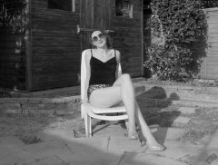 2026-08-01 Estella Rose models her own black sleeveless top and tight animal-print retro girdle worn as hotpants.