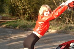 Carlie models red PVC jacket and black shiny pantie girdle worn as hot pants