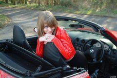 Carlie models red PVC jacket and black shiny pantie girdle worn as hot pants