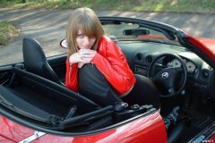 Carlie models red PVC jacket and black shiny pantie girdle worn as hot pants