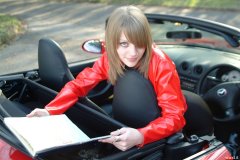 Carlie models red PVC jacket and black shiny pantie girdle worn as hot pants