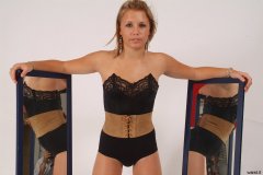 Sara with mirrors in black strapless bra, girdle and suede corset-belt