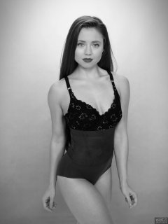 Charlene Joy in black bra and posture top, and purple high-waist control briefs worn as hotpants