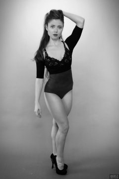 Charlene Joy in black bra and posture top, and purple high-waist control briefs worn as hotpants