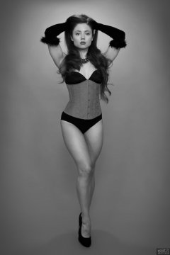 Charlene Joy in tightly-laced red underbust corset, worn over tight black Miraclesuit bodyshaper