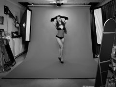 Studio wide-angle shot - Charlene Joy in tightly-laced red underbust corset, worn over tight black Miraclesuit bodyshaper