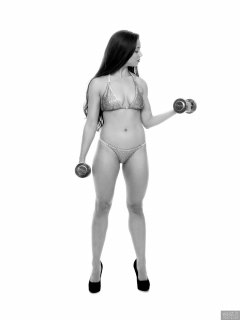 Charlene Joy weightlifting still, in her fitness competition bikini