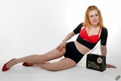 Rebecca Love - plays with vintage Roamer Ten multiband radio, whilst modelling black posture top, red bra and lycra control briefs, worn as hotpants