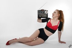 Rebecca Love - plays with vintage Roamer Ten multiband radio, whilst modelling black posture top, red bra and lycra control briefs, worn as hotpants