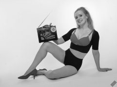 Rebecca Love - plays with vintage Roamer Ten multiband radio, whilst modelling black posture top, red bra and lycra control briefs, worn as hotpants