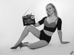 Rebecca Love - plays with vintage Roamer Ten multiband radio, whilst modelling black posture top, red bra and lycra control briefs, worn as hotpants