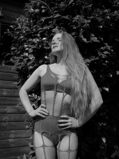 Rebecca Love - in the garden, wearing her own red net bodystocking, worn over matching red bra and girdle