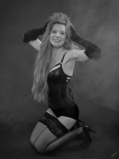 Rebecca Love - tightly-laced black underbust corset, with black wetlook bra and shinly black high-waist girdle worn as hotpants