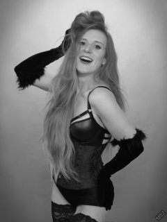 Rebecca Love - tightly-laced black underbust corset, with black wetlook bra and shinly black high-waist girdle worn as hotpants