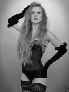 Rebecca Love - tightly-laced black underbust corset, with black wetlook bra and shinly black high-waist girdle worn as hotpants