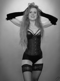Rebecca Love - tightly-laced black underbust corset, with black wetlook bra and shinly black high-waist girdle worn as hotpants