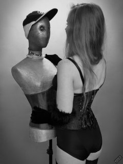 Rebecca Love - tightly-laced black underbust corset, with black wetlook bra and shinly black high-waist girdle worn as hotpants