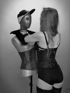 Rebecca Love - tightly-laced black underbust corset, with black wetlook bra and shinly black high-waist girdle worn as hotpants