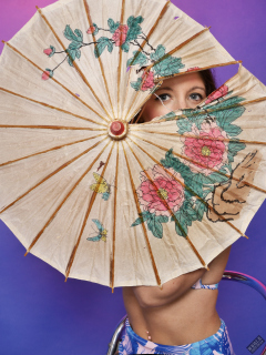 Michelle's Modelling looks through torn umbrella, in her own vintage-style blue bikini