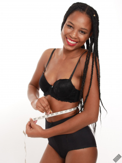 Caleann measuring herself in vintage black sixties-style bra and girdle
