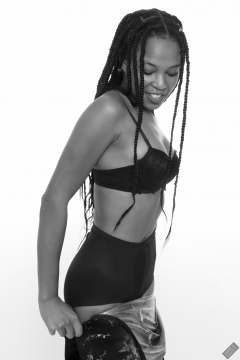 Caleann in black sixties-style bra and girdle, wriggling into tight Cheongsam dress