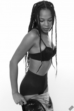 Caleann in black sixties-style bra and girdle, wriggling into tight Cheongsam dress