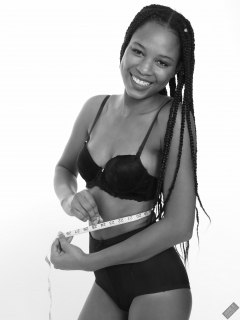 Caleann measuring herself in vintage black sixties-style bra and girdle
