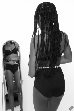 Caleann measuring herself in vintage black sixties-style bra and girdle