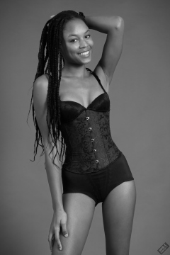 Caleann in tightly-laced black underbust corset, worn over black sixties-style bra and girdle