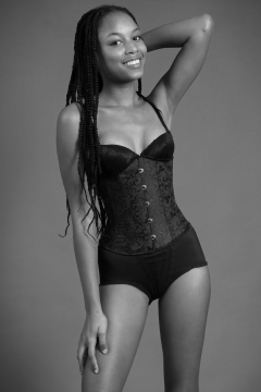 Caleann in tightly-laced black underbust corset, worn over black sixties-style bra and girdle