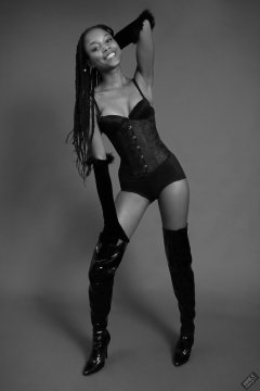 Caleann in tightly-laced black underbust corset, worn over black sixties-style bra and girdle