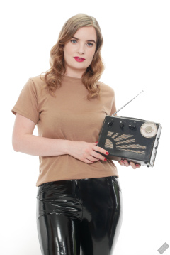 Harriet in her own T-shirt and shiny PVC trousers, demonstrating vintage Roamer Ten multi-band radio receiver