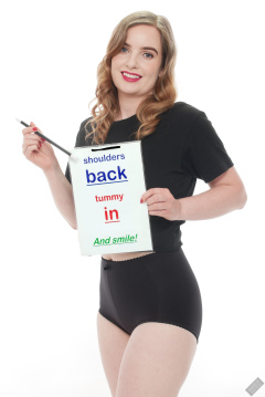 Harriet in black T-shirt, tied at the waist, with black control briefs worn as hotpant