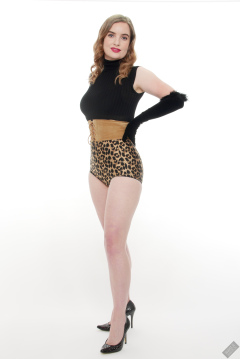 Harriet in black stretchy top, tight leather corset belt and retro-style animal-print control-briefs worn as hotpants