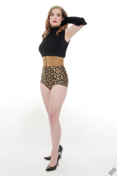 Harriet in black stretchy top, tight leather corset belt and retro-style animal-print control-briefs worn as hotpants