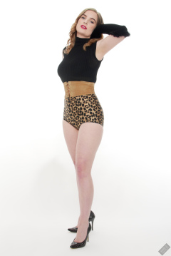Harriet in black stretchy top, tight leather corset belt and retro-style animal-print control-briefs worn as hotpants