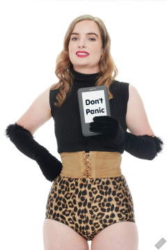 Harriet in black stretchy top, tight leather corset belt and retro-style animal-print control-briefs worn as hotpants
