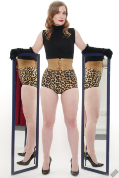 Harriet in black stretchy top, tight leather corset belt and retro-style animal-print control-briefs worn as hotpants