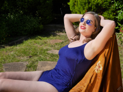 Harriet enjoys the sunshine in blue vintage one-piece swimsuit