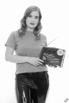 Harriet in her own T-shirt and shiny PVC trousers, demonstrating vintage Roamer Ten multi-band radio receiver