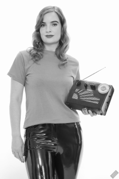 Harriet in her own T-shirt and shiny PVC trousers, demonstrating vintage Roamer Ten multi-band radio receiver