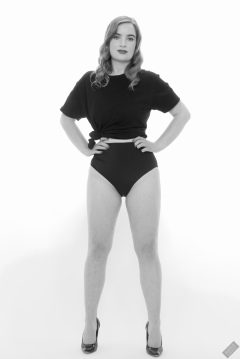 Harriet in black T-shirt, tied at the waist, with black control briefs worn as hotpants