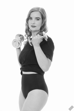 Harriet in black T-shirt, tied at the waist, with black control briefs worn as hotpants